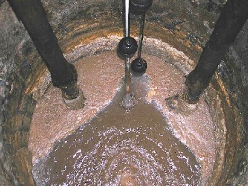 Выгребная яма жир. Канализационный колодец внутри. Фекальный колодец. Приспособление для чистки выгребных ям. Вода в канализационном колодце.